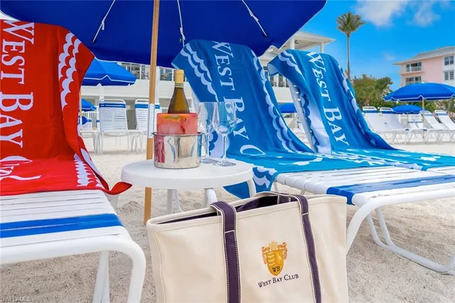 a view of a patio with a table and chairs under an umbrella with large trees