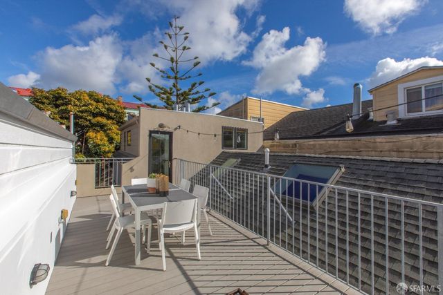 a view of a yard with flower plants and wooden fence