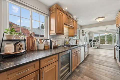 a large kitchen with stainless steel appliances granite countertop a sink and a wooden floors