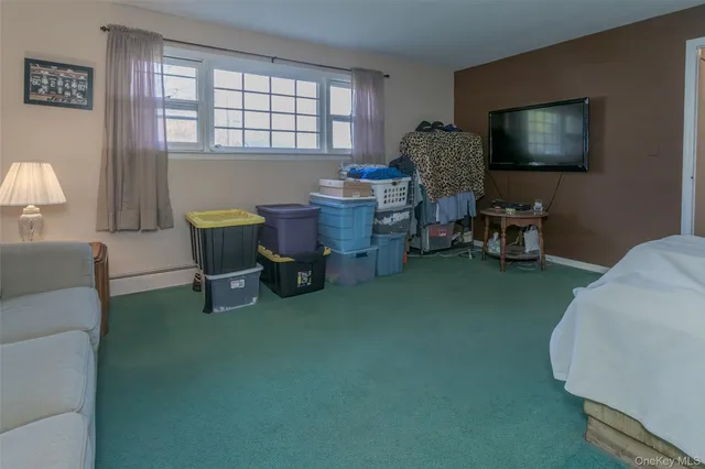 a living room with furniture a flat screen tv and a window