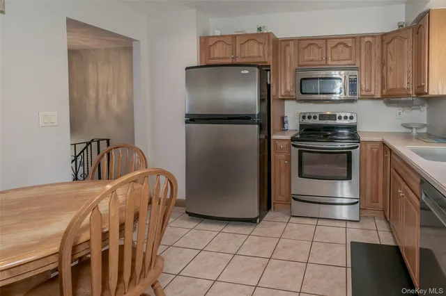 a kitchen with stainless steel appliances granite countertop a refrigerator a stove a sink and a microwave