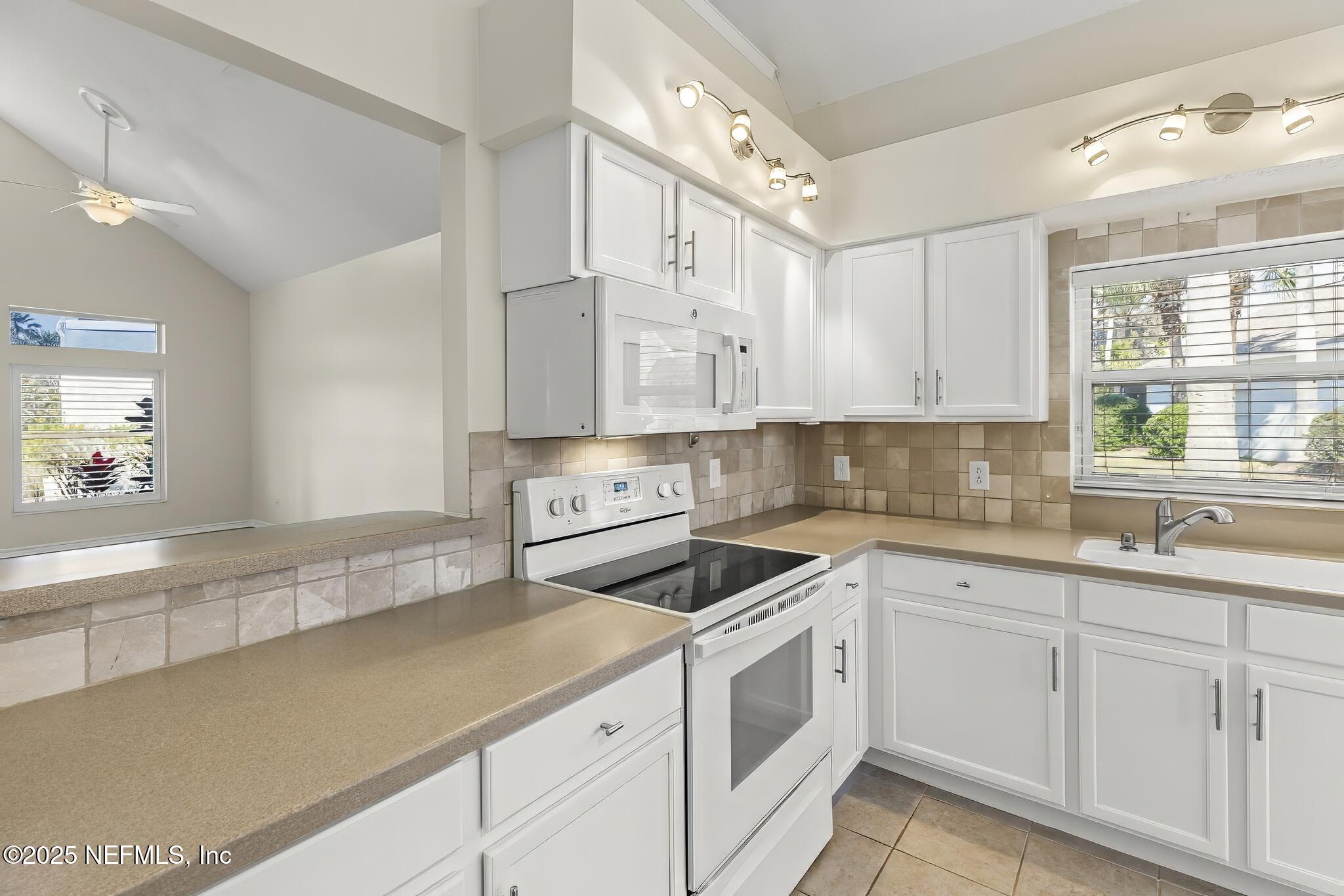 180 Kingston Drive St. Augustine, FL 32084 - Photo 12 of 55 a kitchen with white cabinets and white appliances