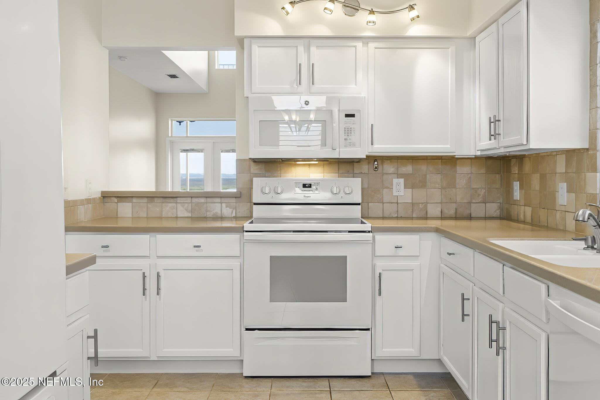 180 Kingston Drive St. Augustine, FL 32084 - Photo 13 of 55 a kitchen with granite countertop white cabinets and white appliances