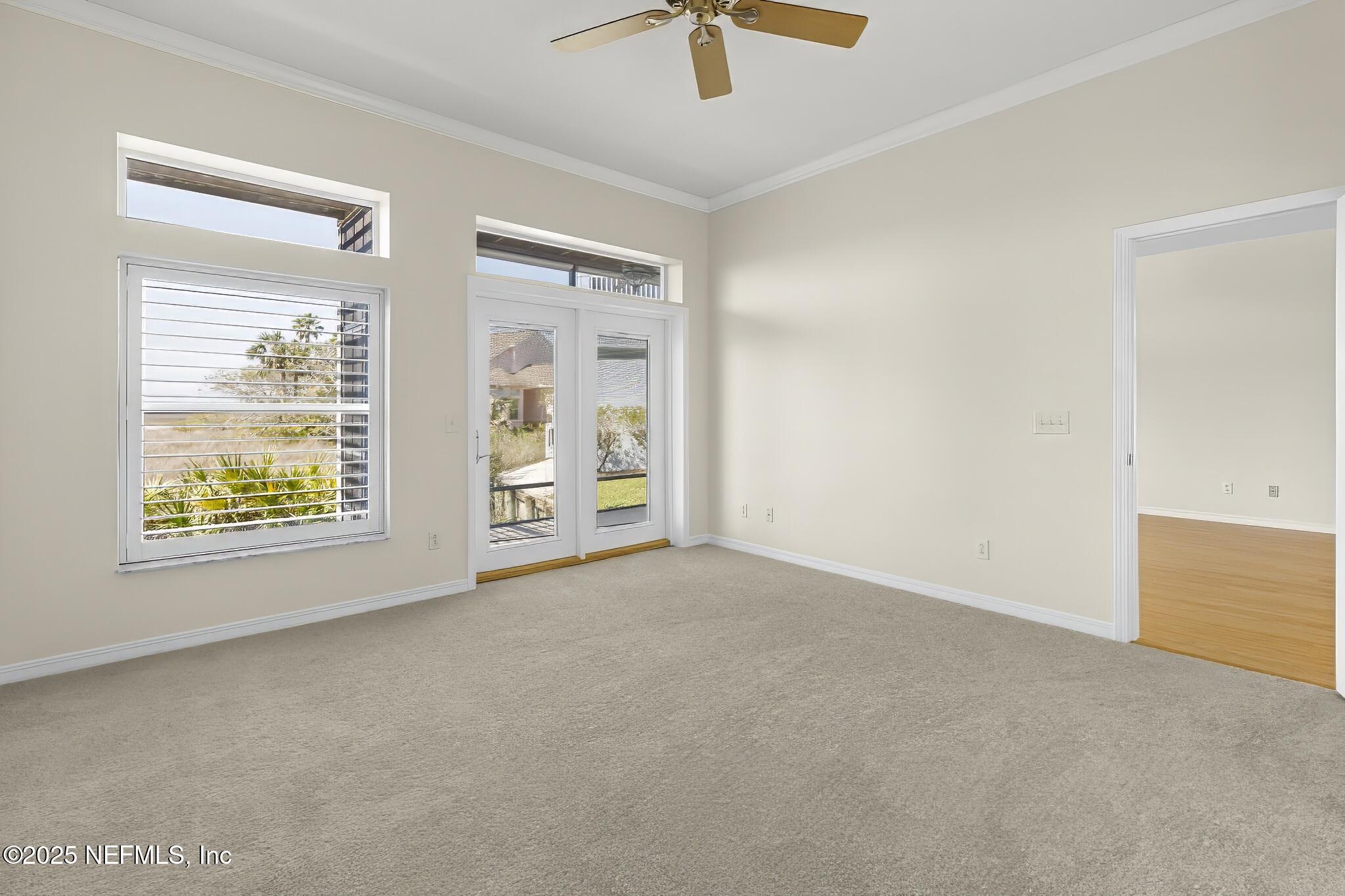 180 Kingston Drive St. Augustine, FL 32084 - Photo 19 of 55 an empty room with windows and chandelier fan