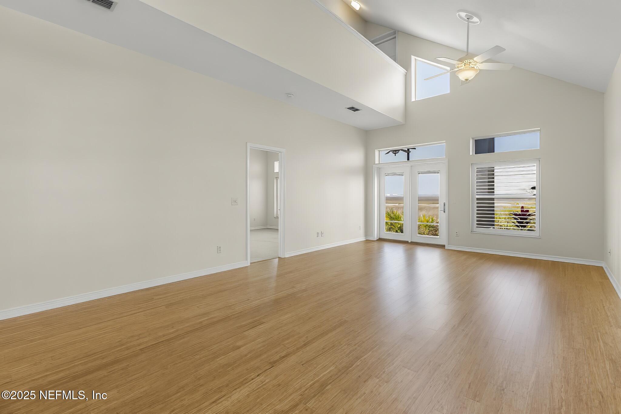 180 Kingston Drive St. Augustine, FL 32084 - Photo 6 of 55 a view of an empty room with window and wooden floor