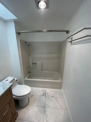 a bathroom with a toilet and a shower