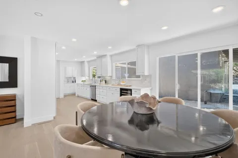 a dining room with furniture a fireplace and kitchen view