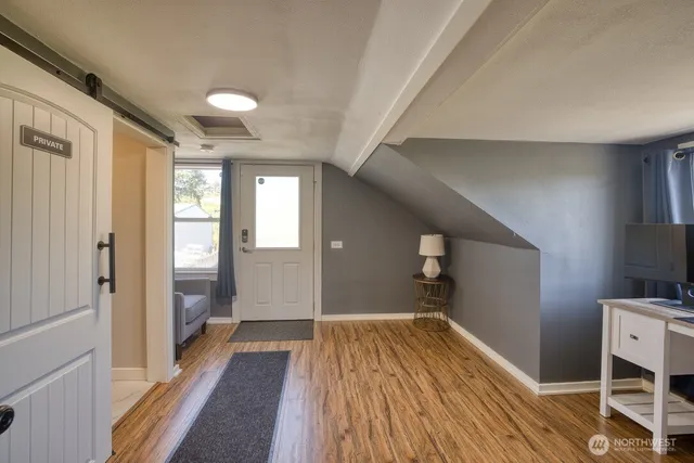 a view of a hallway with wooden floor and staircase