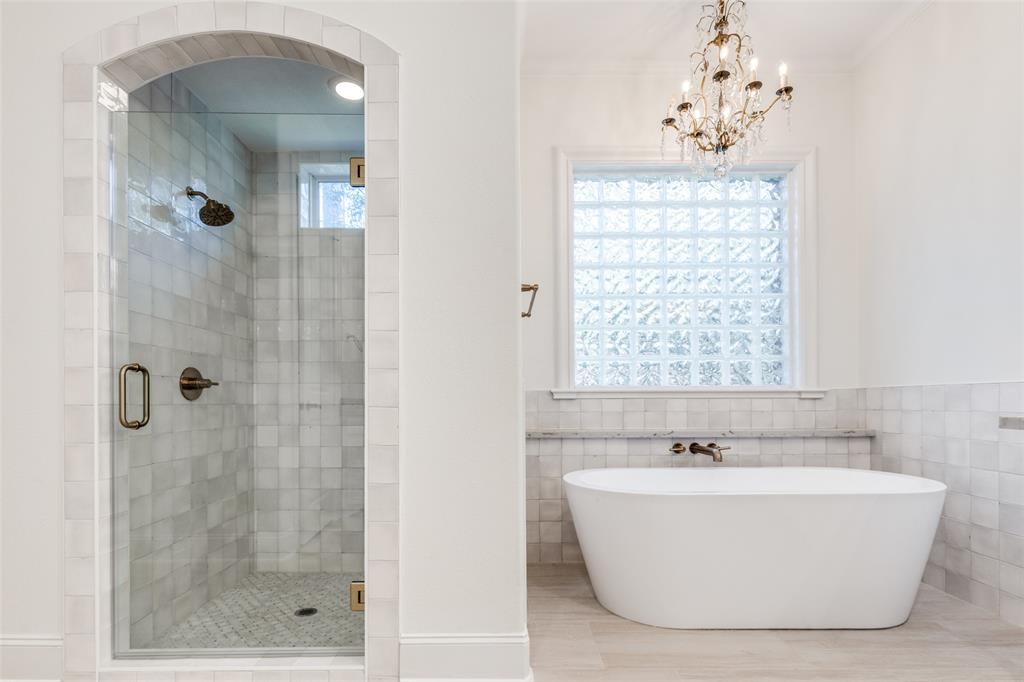 4111 Angling Lane Spring, TX 77386 - Photo 12 of 27 Bathroom with a freestanding tub, a shower stall, tile walls, and hanging lights