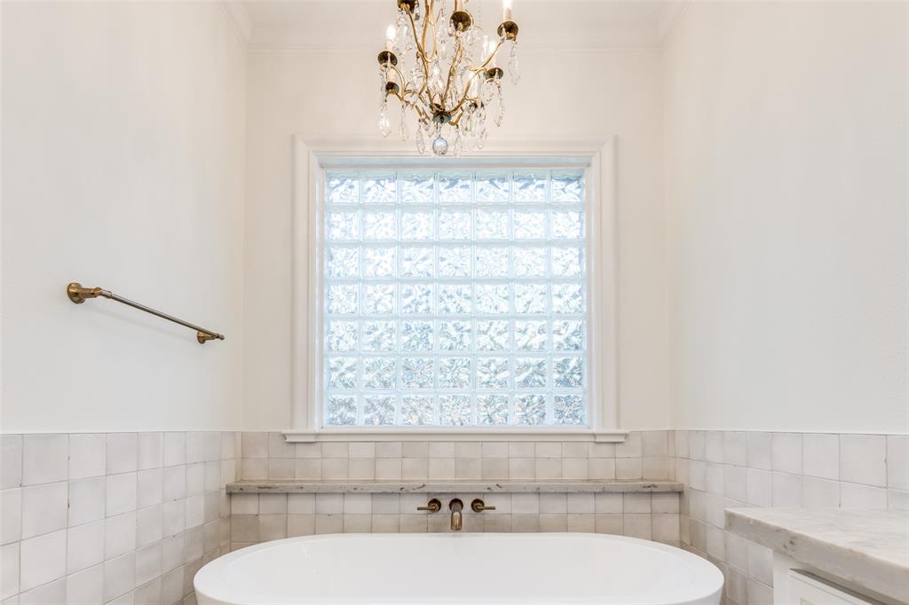 4111 Angling Lane Spring, TX 77386 - Photo 13 of 27 Full bathroom with tile walls, a wainscoted wall, a tub, and a chandelier