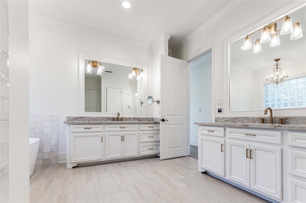 4111 Angling Lane Spring, TX 77386 - Photo 14 of 27 Bathroom with a freestanding bath, two vanities, ornamental molding, tile walls, and a chandelier