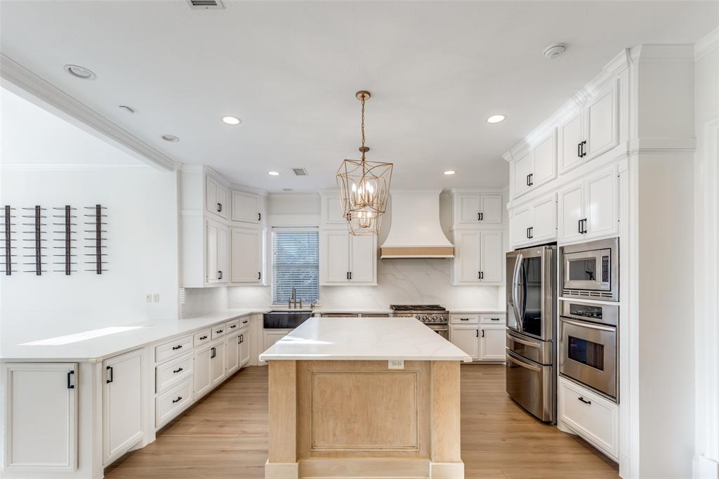4111 Angling Lane Spring, TX 77386 - Photo 8 of 27 Kitchen with stainless steel appliances, a peninsula, a center island, decorative backsplash, and hanging lights