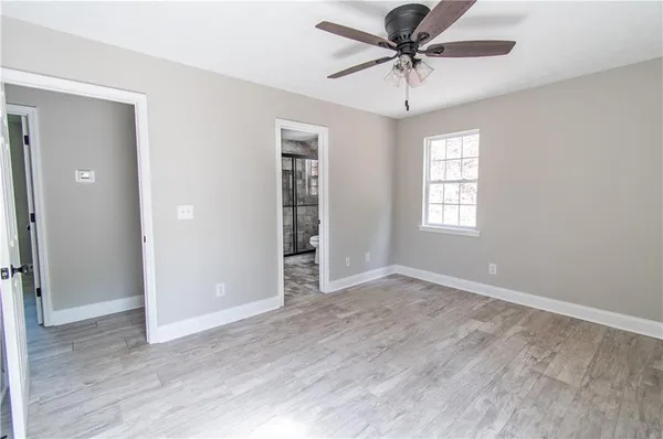 an empty room with a window and a fan