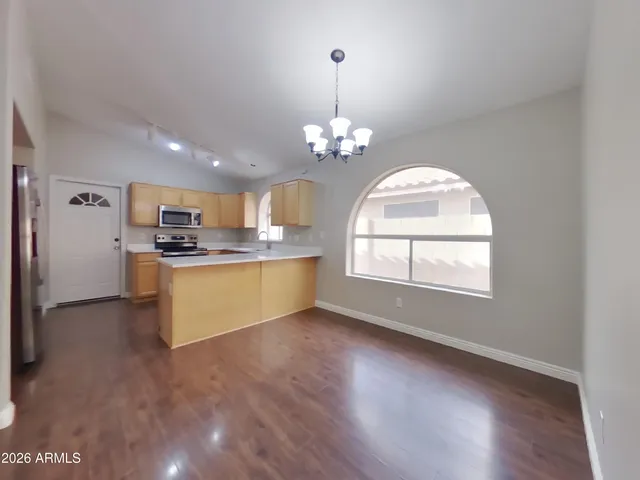 a kitchen with stainless steel appliances white cabinets a sink a stove a refrigerator and microwave