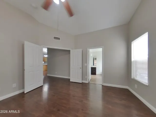 an empty room with wooden floor and windows