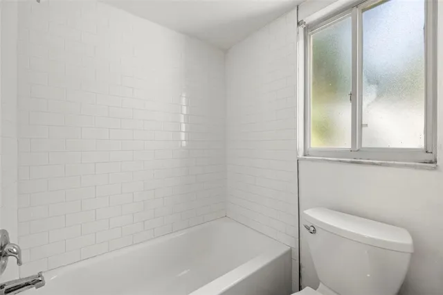 a bath tub sitting next to a white toilet