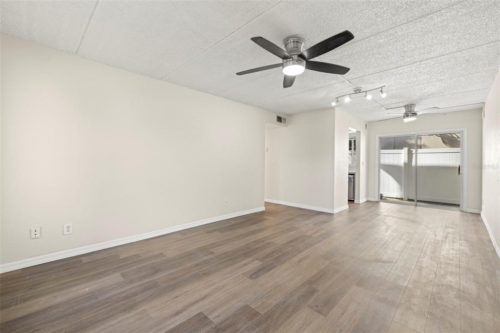 3206 West Azeele Street, Unit 128 Tampa, FL 33609 - Photo 5 of 18 an empty room with wooden floor and a ceiling fan