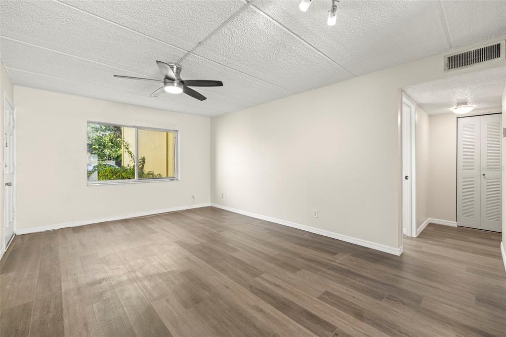 3206 West Azeele Street, Unit 128 Tampa, FL 33609 - Photo 6 of 18 an empty room with wooden floor ceiling fan and windows