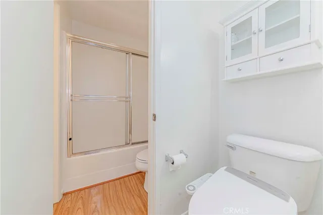 a white toilet sitting next to a shower