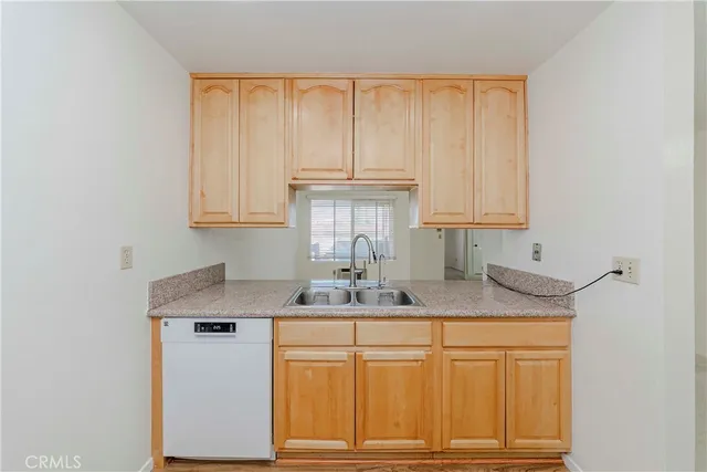 a kitchen with stainless steel appliances granite countertop white cabinets and a window