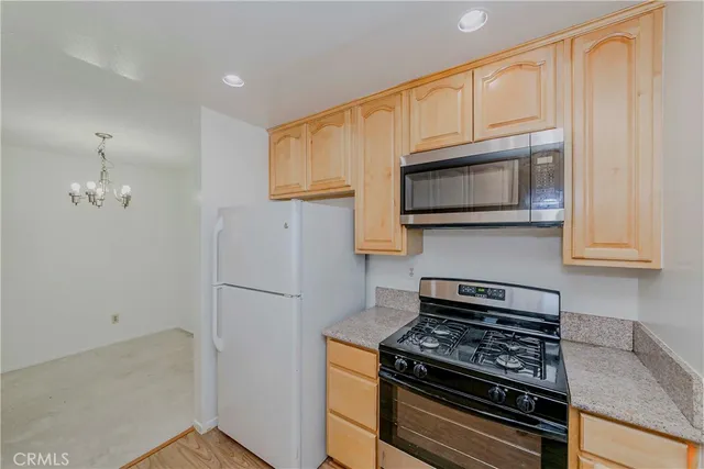 a kitchen with stainless steel appliances white cabinets and a stove top oven