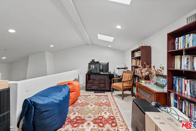 a living room with furniture and a book shelf