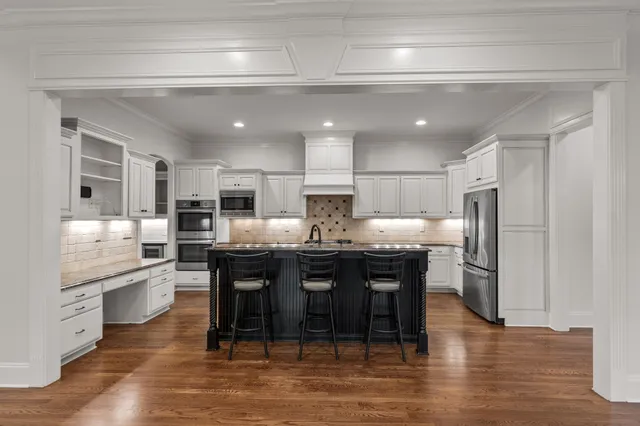 a kitchen with granite countertop a table chairs sink and cabinets