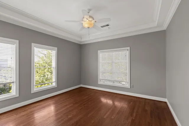 a view of a house with a small yard and a large tree