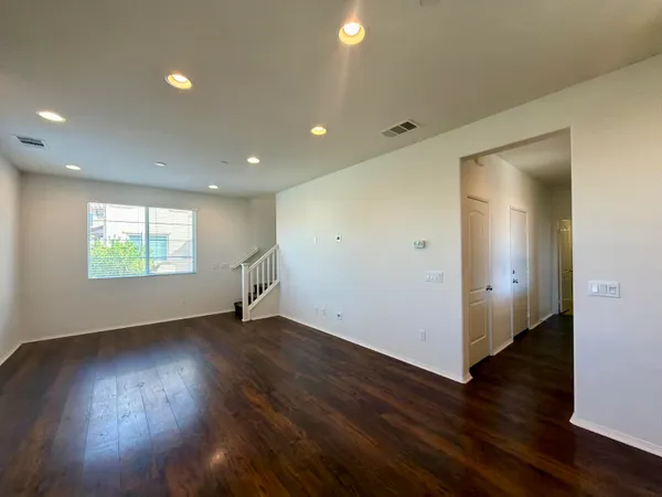 an empty room with wooden floor and windows