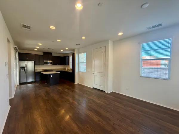 a view of kitchen with kitchen island microwave and refrigerator