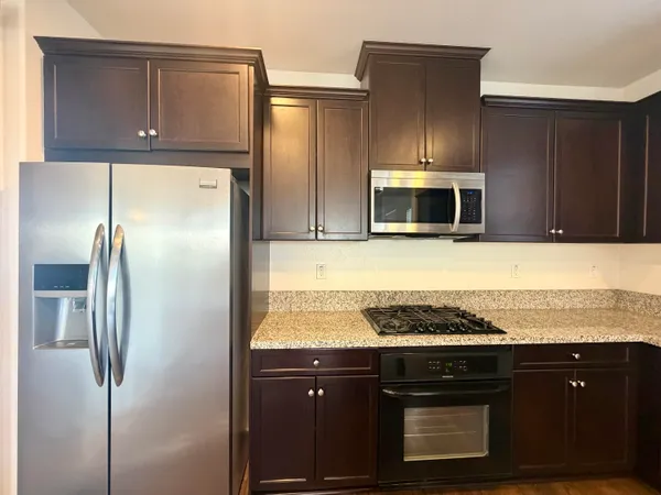 a kitchen with stainless steel appliances granite countertop a refrigerator and a stove