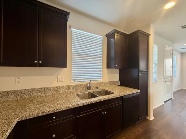 a kitchen with granite countertop cabinets and refrigerator