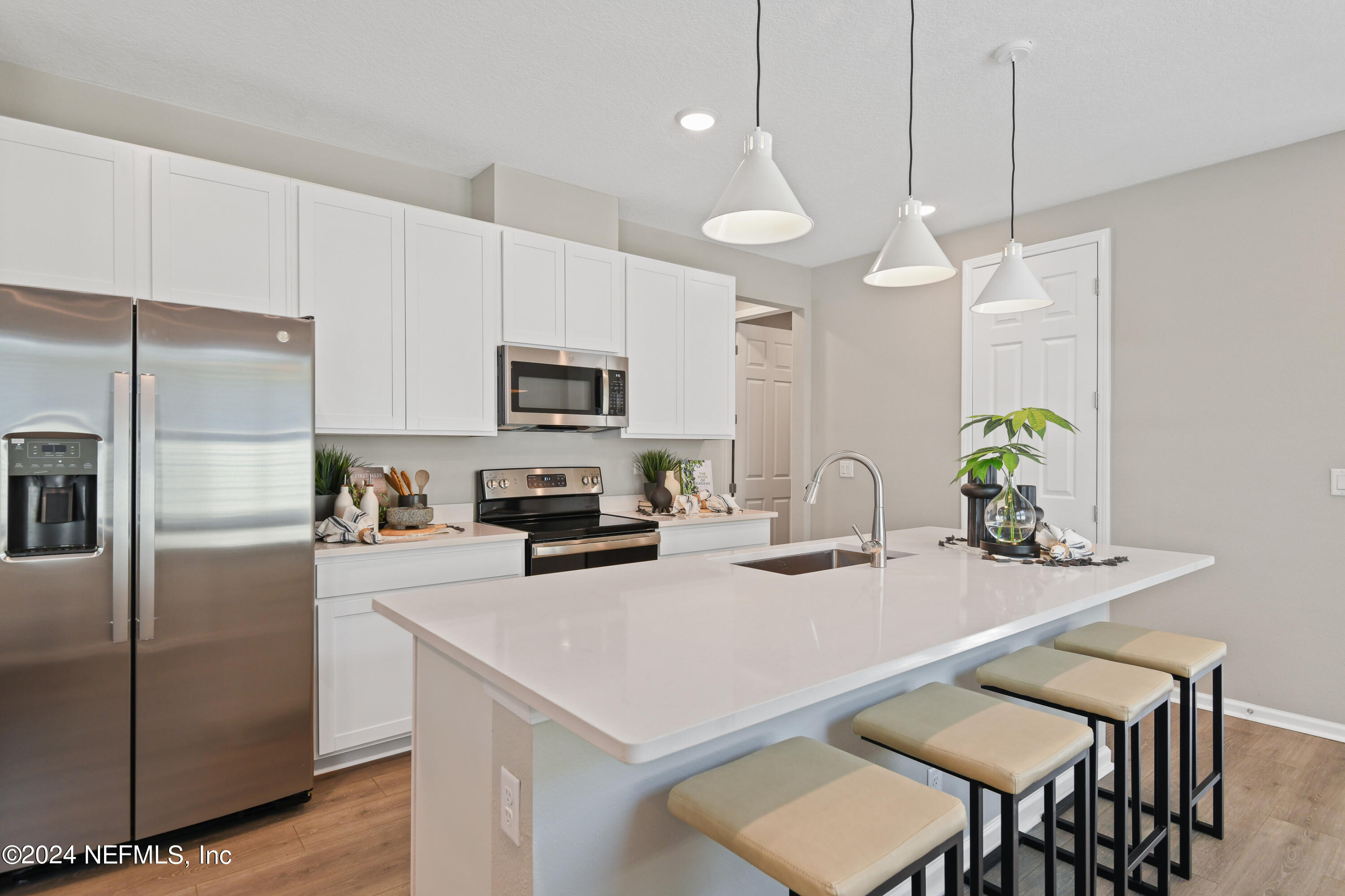333 Cedar Elm Way St. Augustine, FL 32092 - Photo 5 of 24 a kitchen with kitchen island a dining table chairs stainless steel appliances and cabinets