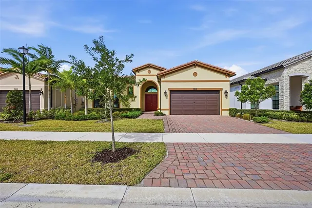 a front view of a house with a garden and garage
