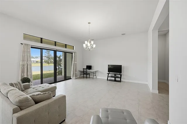 a living room with furniture a flat screen tv and a large window