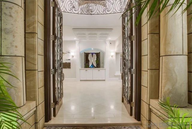 a view of a big room with entryway chandelier and glass door
