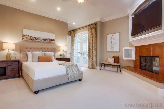 a spacious bedroom with a bed and a flat screen tv