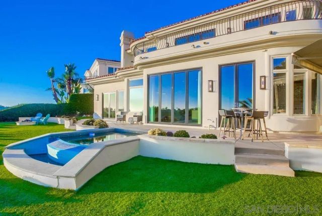 an aerial view of a backyard with swimming pool and outdoor seating