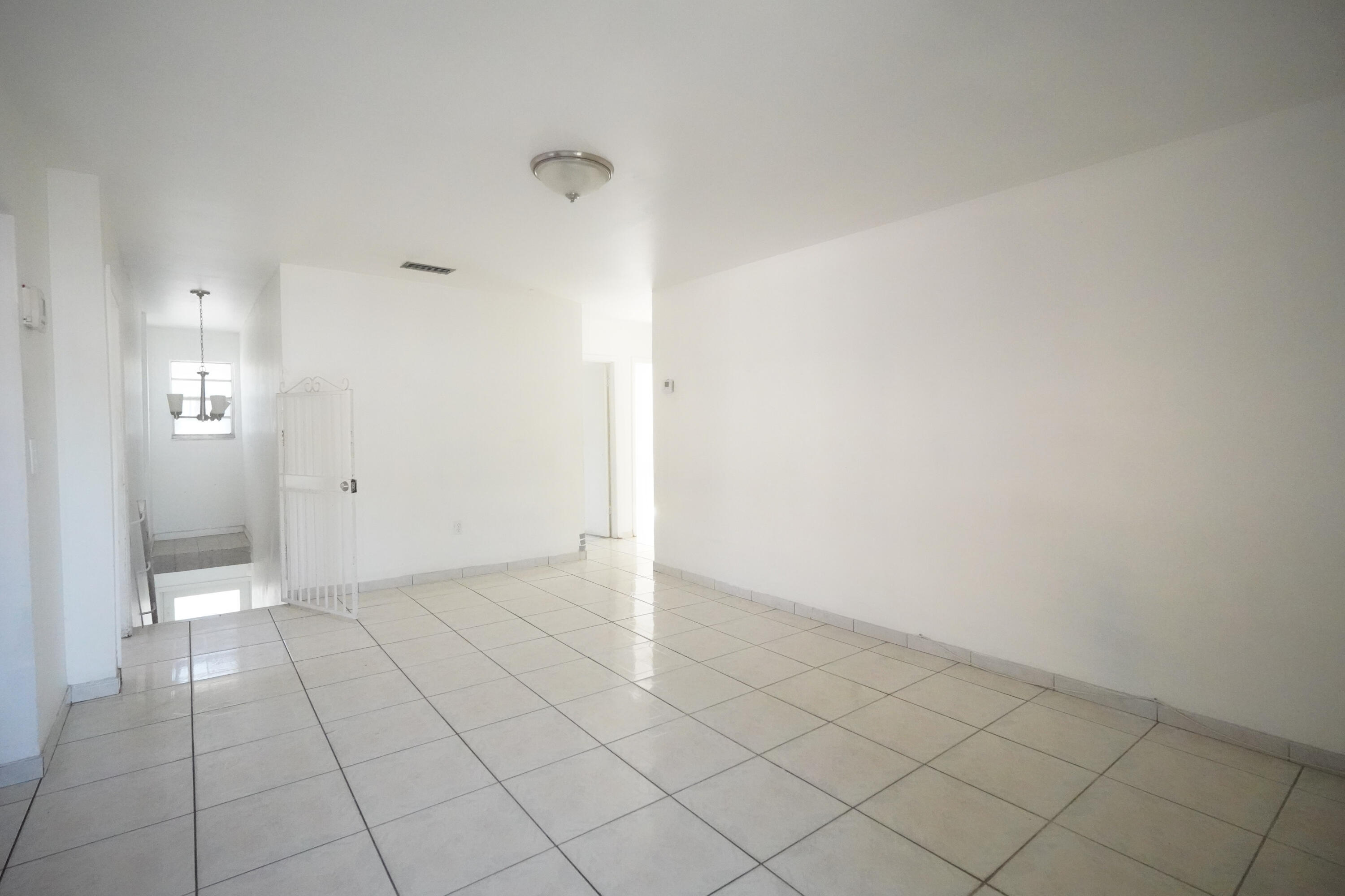 1882 Southwest 17th Avenue Miami, FL 33145 - Photo 2 of 28 an empty room with white walls and tiles