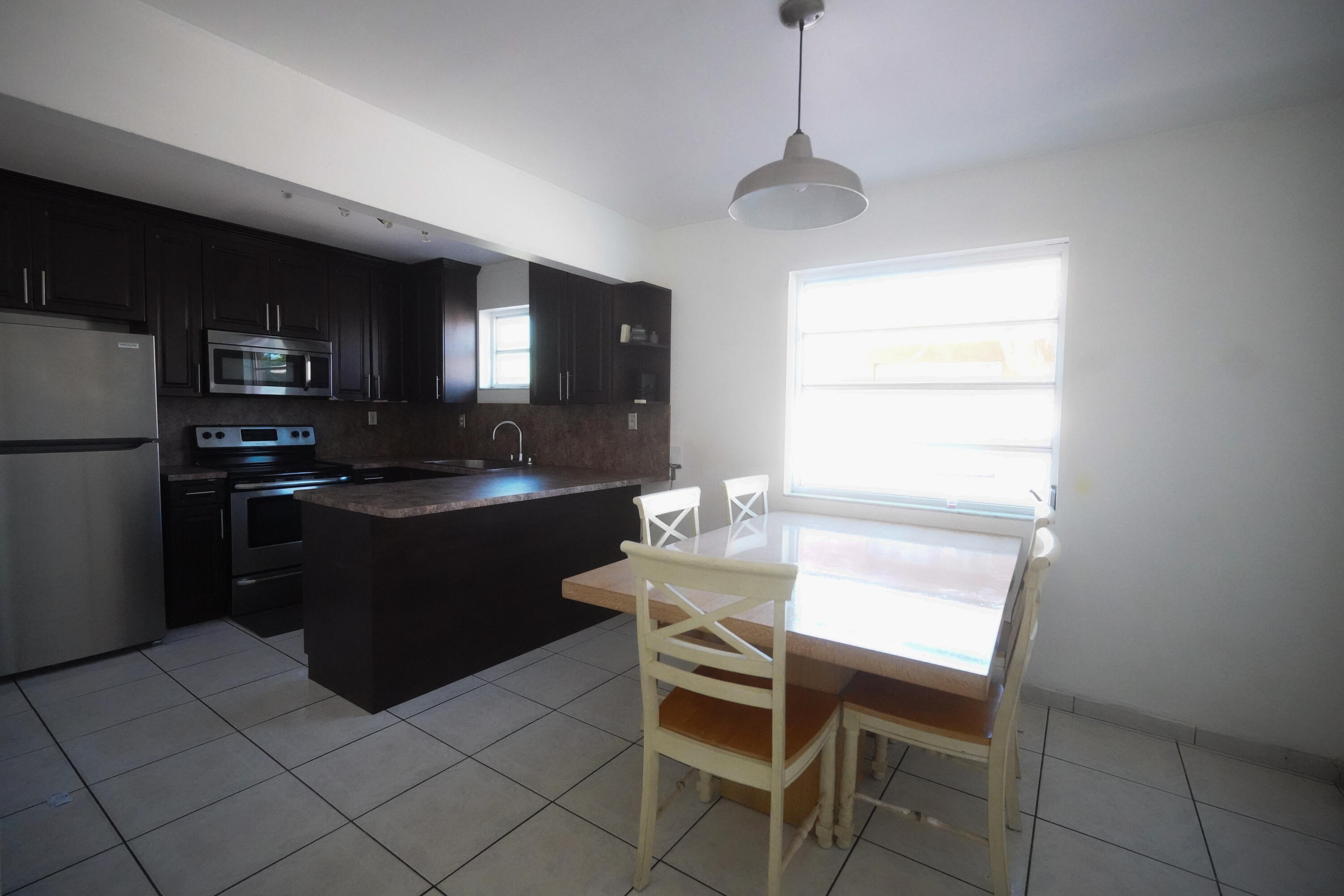 1882 Southwest 17th Avenue Miami, FL 33145 - Photo 26 of 28 a kitchen with a refrigerator and a stove top open
