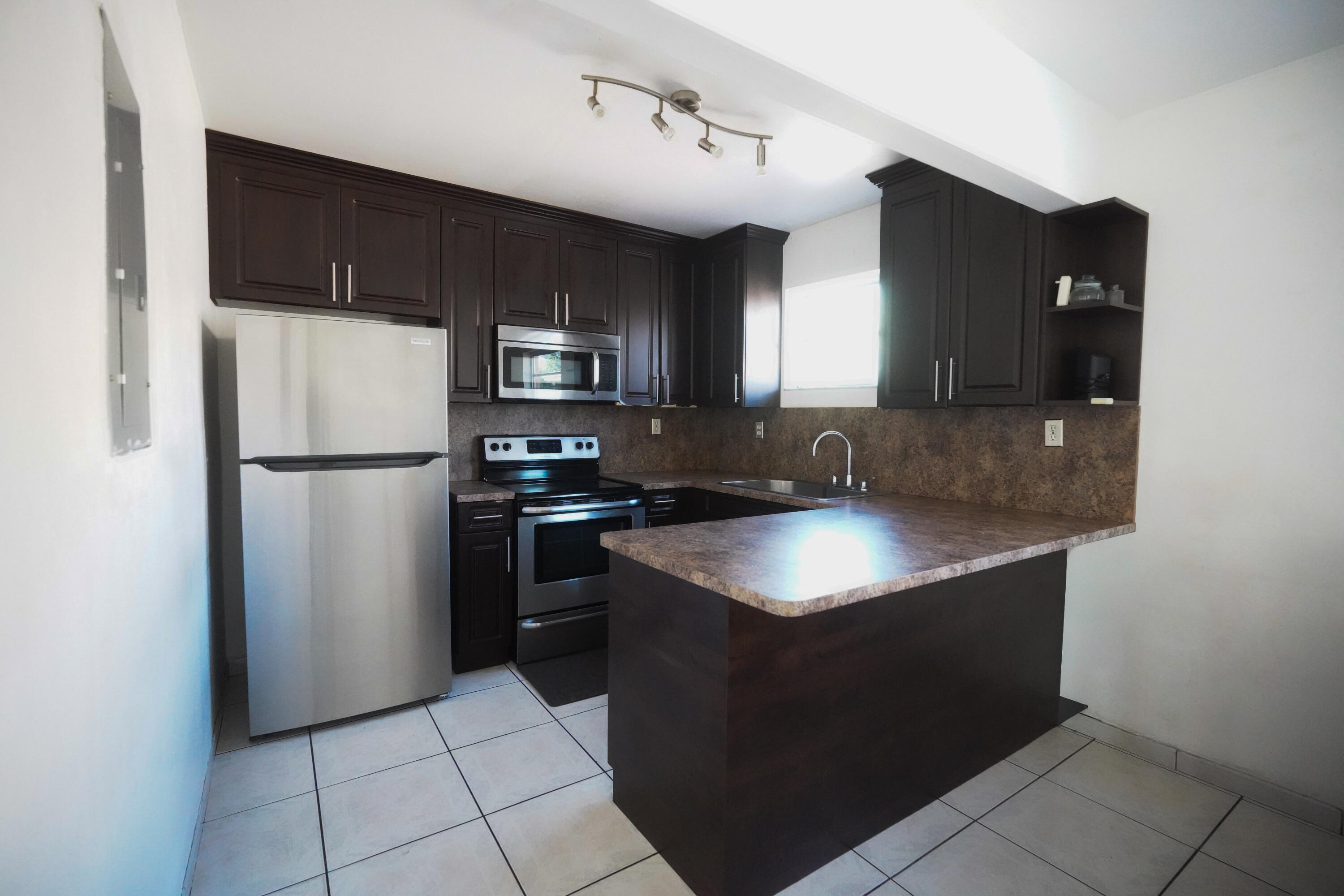 1882 Southwest 17th Avenue Miami, FL 33145 - Photo 27 of 28 a kitchen with stainless steel appliances granite countertop a refrigerator a stove a sink and a microwave
