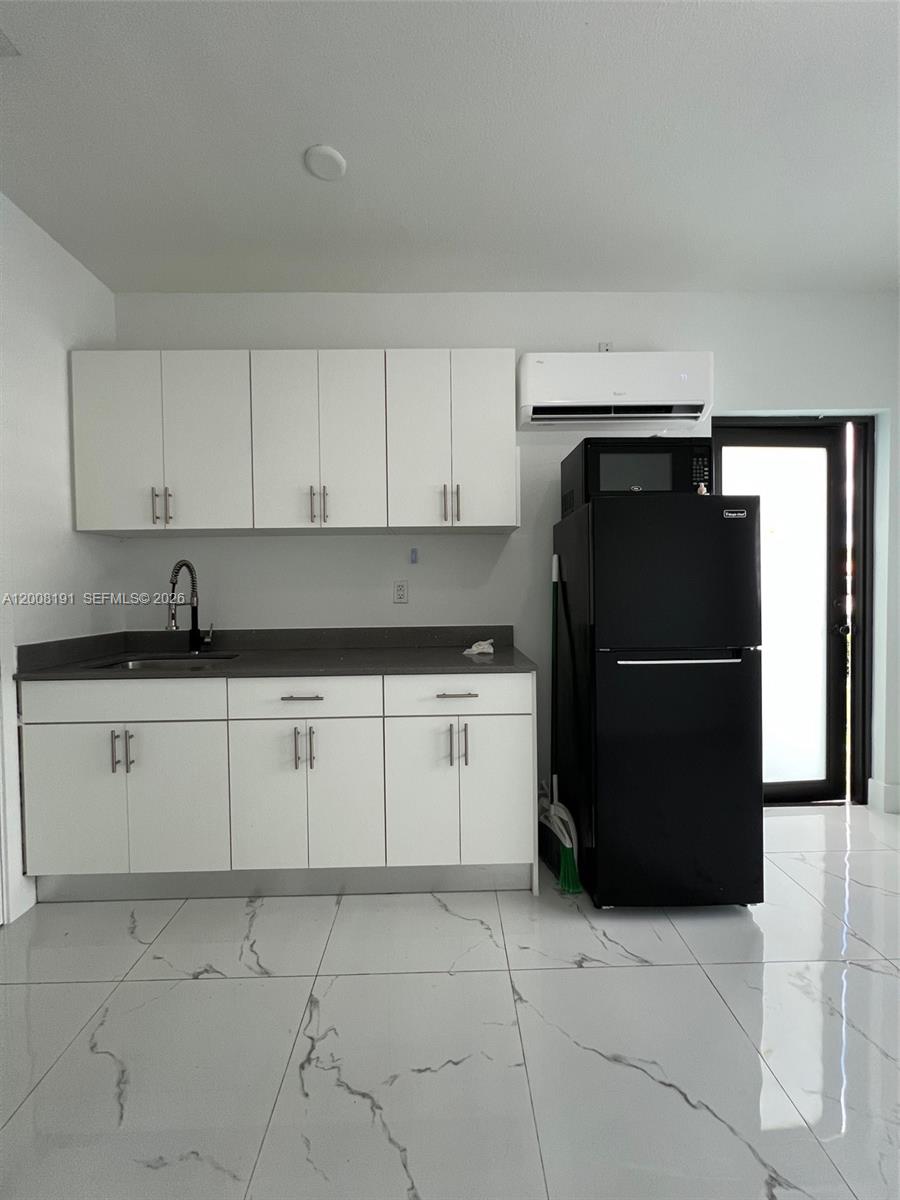 20007 Southwest 122nd Court, Unit 20007B Miami, FL 33177 - Photo 4 of 9 a kitchen with a refrigerator and cabinets