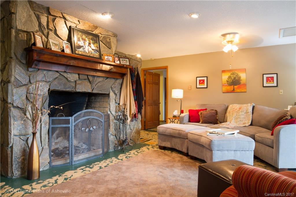 8 Elmers Place Fairview, NC 28730 - Photo 17 of 21 a living room with furniture a flat screen tv and a fireplace