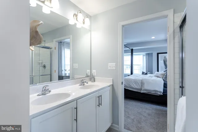 a en suite bathroom with double vanity sinks a vanity and a mirror