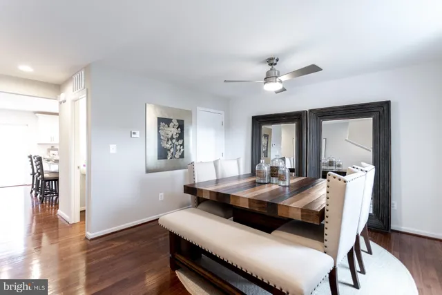 a dining room with wooden floor a chandelier a wooden table and chairs