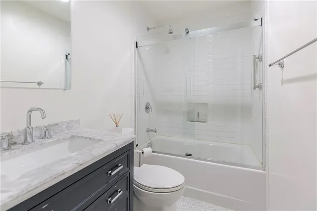 a bathroom with a granite countertop sink a toilet and a mirror