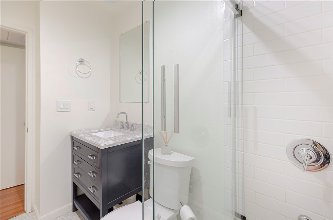 5400 Newcastle Avenue, Unit 70 Encino, CA 91316 - Photo 13 of 32 a bathroom with a granite countertop sink a toilet and a mirror