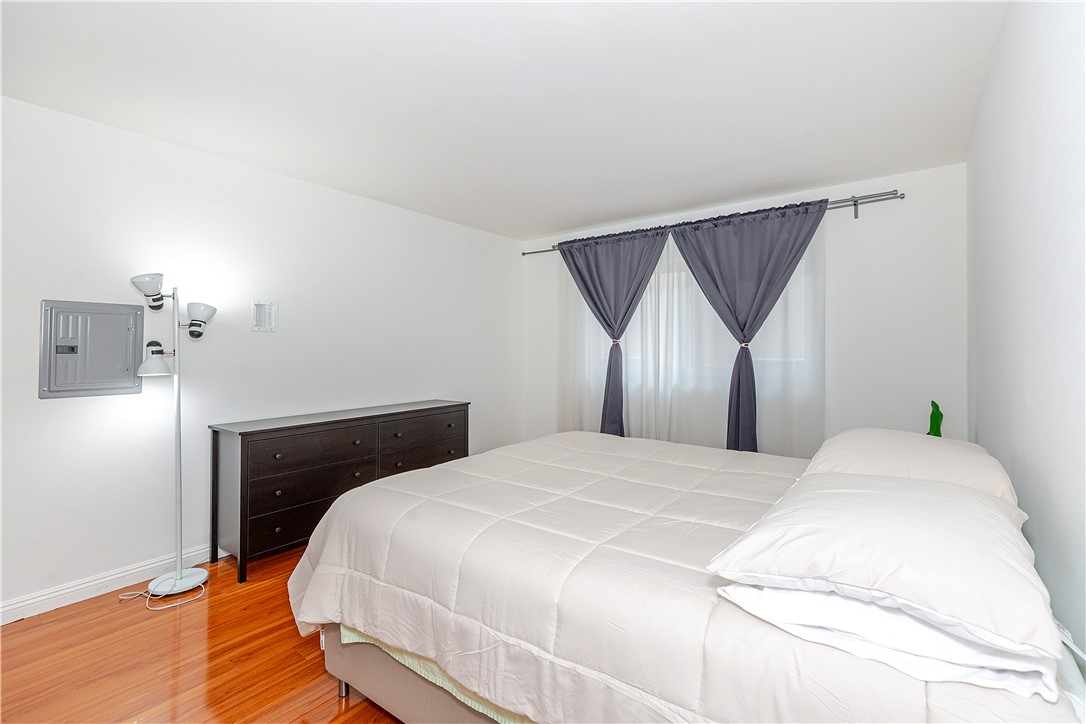 5400 Newcastle Avenue, Unit 70 Encino, CA 91316 - Photo 20 of 32 a bedroom with a bed and wooden floor