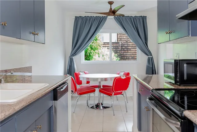 a kitchen with kitchen island granite countertop a sink stove and refrigerator