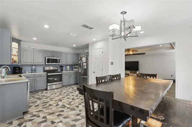 a kitchen with a table chairs stove and refrigerator